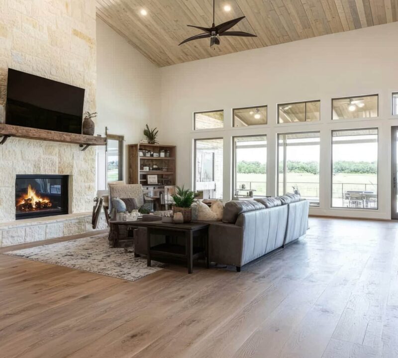 Cozy barndominium living room featuring a welcoming fireplace, rustic decor, wooden beams, and comfortable seating for relaxation.